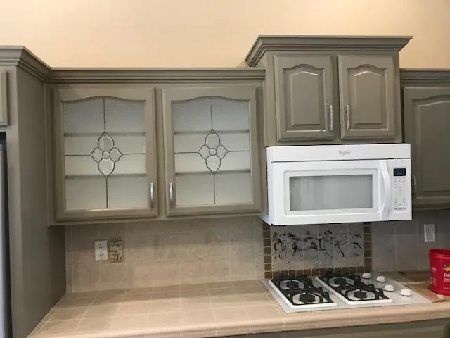 The same kitchen after the cabinets were refinished in a warm grey