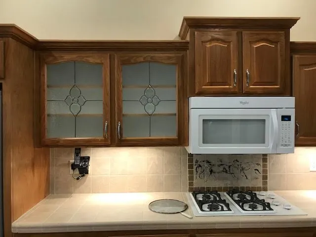 Kitchen with original honey‑oak cabinets before refinishing