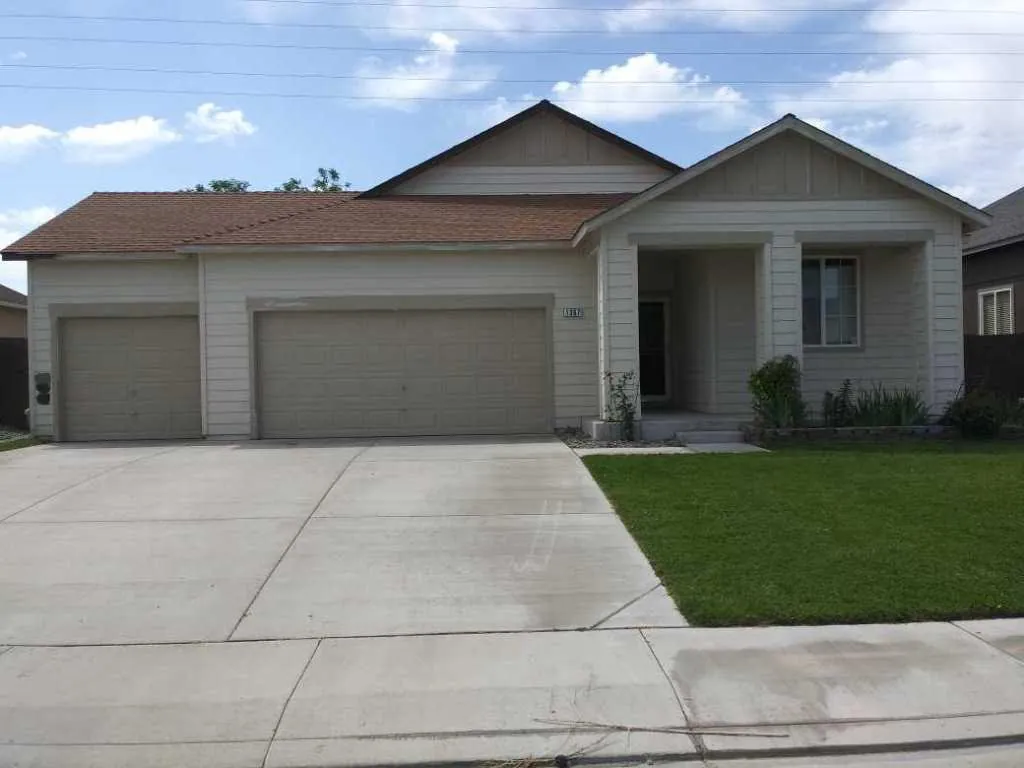 Grey stucco home with three‑car garage