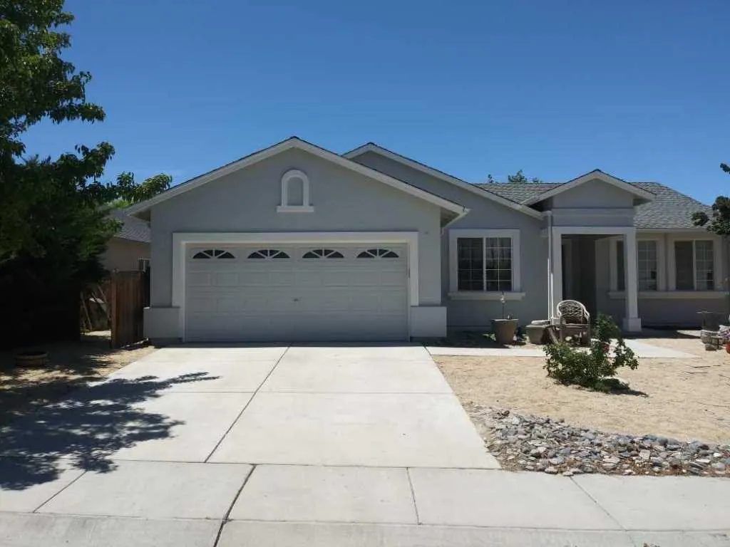 Grey stucco home with painted garage door