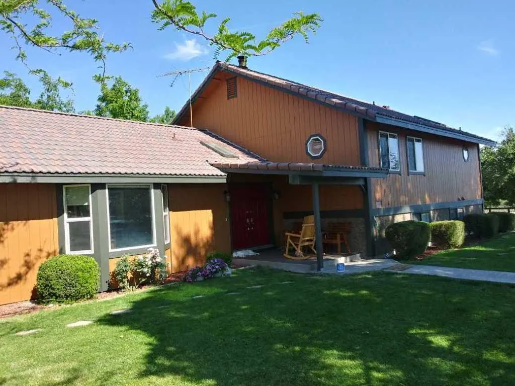 Ranch home repainted in terracotta with red door