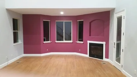 Living room painted deep plum with white trim